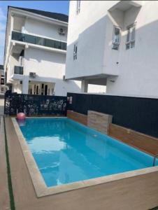 a swimming pool in front of a building at Alexa Smart Home One Bedroom Luxury Apartment in Lekki