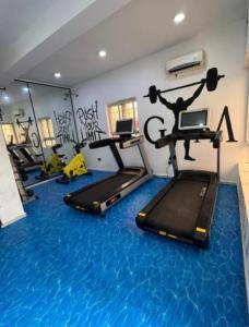 a gym with treadmills and exercise equipment on the floor at Alexa Smart Home One Bedroom Luxury Apartment in Lekki