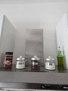 a shelf with three jars on top of a microwave at Nido Ticino in Bernate Ticino