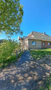 a house with a fence next to a yard at Nordmannsland I in Sudermarsch
