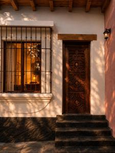 a building with a wooden door and stairs in front at Suite Privada Nueva Boutique con Entrada Independiente y Acceso Autónomo, A 5 Min del Centro in Pátzcuaro