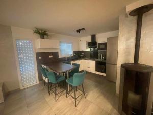 a kitchen with a table and blue chairs in a room at Silver in Quessoy