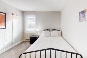 a white bedroom with a bed and a window at Mountain Walk by Property Valet in Blue Mountains +32 photos