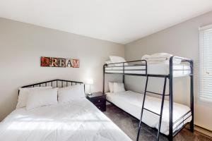 a bedroom with two bunk beds and a window at Mountain Walk by Property Valet in Blue Mountains