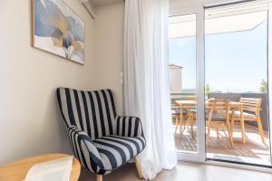 a living room with a chair and a table at DreamCoast Apartments I in Artemida