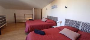 a bedroom with two beds with red comforters at Villa Margo in Cognac