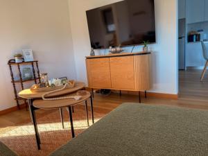 a living room with a table and a tv at House overlooking the Douro-Casa das Almas in Paços de Gaiolo