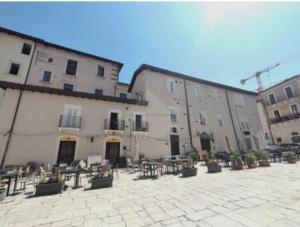 a large building with tables and chairs in a courtyard at JeD SWEET DREAMS in LʼAquila
