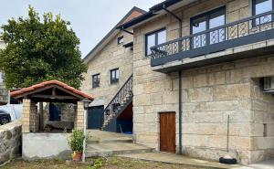 a brick building with a door and a balcony at House overlooking the Douro-Casa das Almas in Paços de Gaiolo