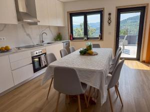 a kitchen with a table and chairs in a kitchen at House overlooking the Douro-Casa das Almas in Paços de Gaiolo