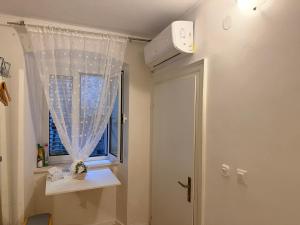 a bathroom with a window and a white curtain at Luxury rooms in Split