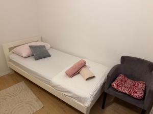a small bedroom with a bed and a chair at Luxury rooms in Split