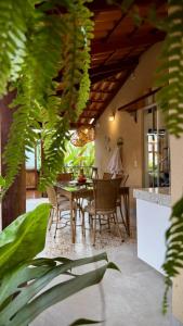 a dining room with a table and chairs and plants at Pousada Mãe Natureza in Pirenópolis