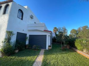 una casa bianca con due porte da garage nel cortile di Basatine a Saïdia