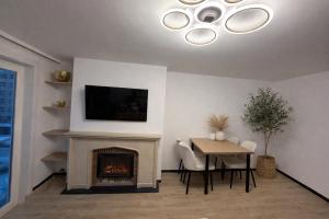 a living room with a table and a fireplace at Marine Résidence in De Panne