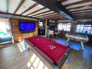 a room with a pool table and a flat screen tv at 8 BR Luxury Farmhouse | Tennis Court & EV Charging in Tile Hill