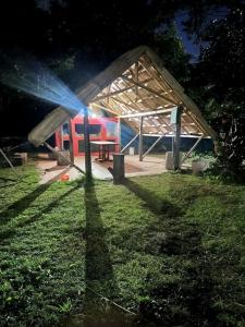 a building with a picnic table in the grass at Quinta Rancho Pingos in General Rodríguez +1 photo