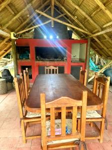 a wooden table with chairs and a beam of light at Quinta Rancho Pingos in General Rodríguez