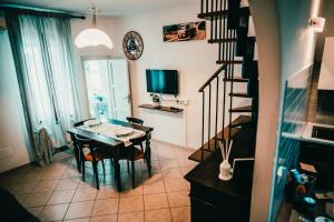a dining room with a table and chairs and a staircase at Bixio 7 Boutique stay in Imola