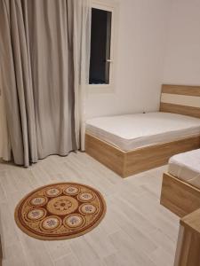 a room with two beds and a rug on the floor at Amazing lagoon view chalet 3 bedrooms in Marsa Matruh