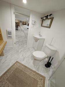 ein weißes Badezimmer mit Toilette und Teppich in der Unterkunft Quiet Ocean View Open Concept, Loft Style Studio within Forested Area, Near Parks & Ferry in Nanaimo + 45 Fotos