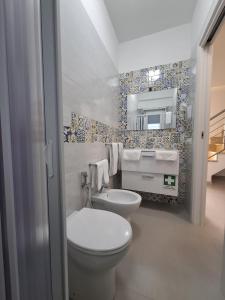a bathroom with a toilet and a sink and a mirror at Le Casette Del Mare in Crotone