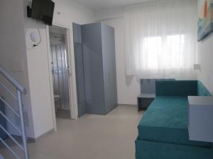 a living room with a green couch in a room at Le Casette Del Mare in Crotone