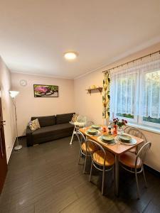 a living room with a table and chairs and a couch at Ptasi Raj in Karwia