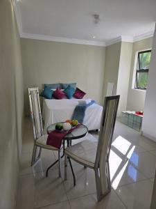a room with a bed and a table and chairs at Aquasaints Sandton Logde in Johannesburg