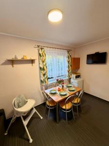 a kitchen and dining room with a table and chairs at Ptasi Raj in Karwia