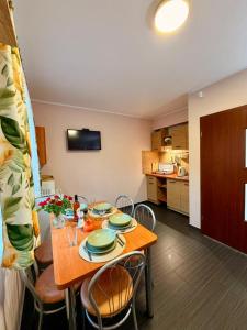 a dining room with a table and a kitchen at Ptasi Raj in Karwia