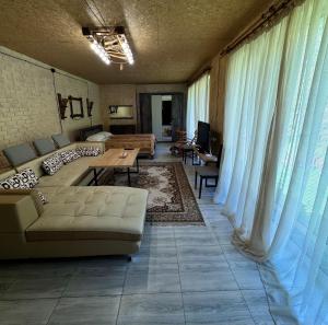 a living room with a couch and a table at Riviera Guesthouse in Dilijan