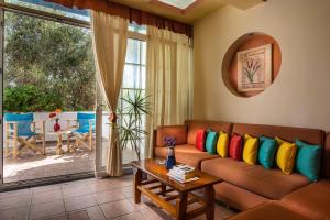 a living room with a couch with colorful pillows at Hotel Dionysis Studios in Adamantas