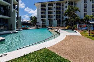 a swimming pool in front of a building at 2nd Floor 1-Bedroom Apartment in Urangan