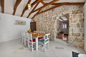 a kitchen with a table and chairs and a stone wall at Villa Stone-Exceptional private Estate in Mlini