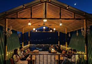 a group of people sitting at tables in a pavilion at Chilux Manali in Manāli +33 photos
