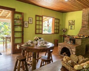 a living room with a table and a fireplace at Rancho Pôr Do Sol in Arapeí