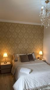 a bedroom with a bed and two lamps and a chandelier at Hotel Casa Dharma in Popayan