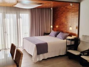 a hotel room with a bed and a chair at Apartamentos El Arrecife in Conil de la Frontera