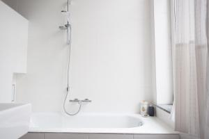 a white bath tub sitting next to a white sink at B&B Villa 36 in Brussels