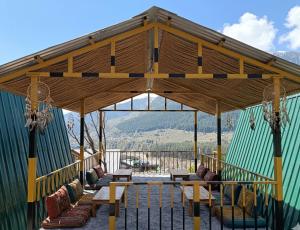 a gazebo with couches and chairs under it at Chilux Manali in Manāli