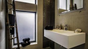 a bathroom with a white sink and a window at JC Seaside in Vila Franca do Campo