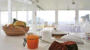 a table with a plate of bread and a basket of fruit at JC Seaside in Vila Franca do Campo