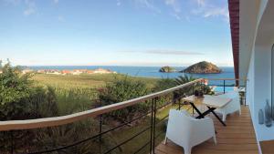 a balcony with a table and chairs and the ocean at JC Seaside in Vila Franca do Campo