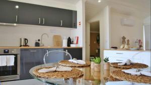 a kitchen with a glass table with towels on it at JC Seaside in Vila Franca do Campo +2 photos