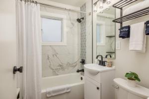 a white bathroom with a shower and a sink at Modern Studio Downtown Anchorage in Anchorage