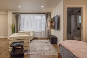 a bedroom with a bed and a couch and a bathroom at Modern Studio Downtown Anchorage in Anchorage