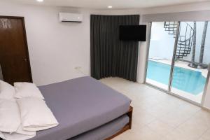 a bedroom with a bed and a television in it at Casa con alberca en el centro de Puerto Progreso in Progreso
