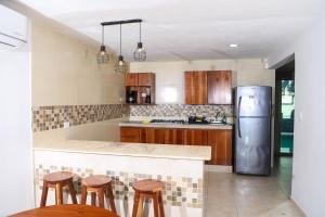 a kitchen with a stainless steel refrigerator and wooden cabinets at Casa con alberca en el centro de Puerto Progreso in Progreso