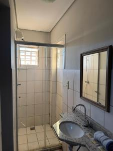 a bathroom with a sink and a shower with a mirror at Hotel Norte Sul in Campo Grande +74 photos
